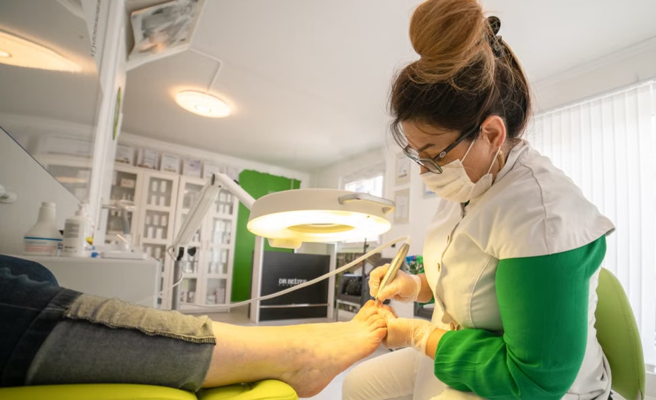 Podiatrist treating a patient's foot in the clinic chair