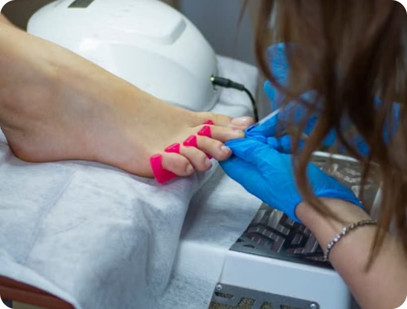 Toenails being treated under a nail lamp
